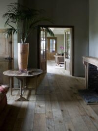 Magma Pacaya rustic floor in barn conversion with fireplace and palm